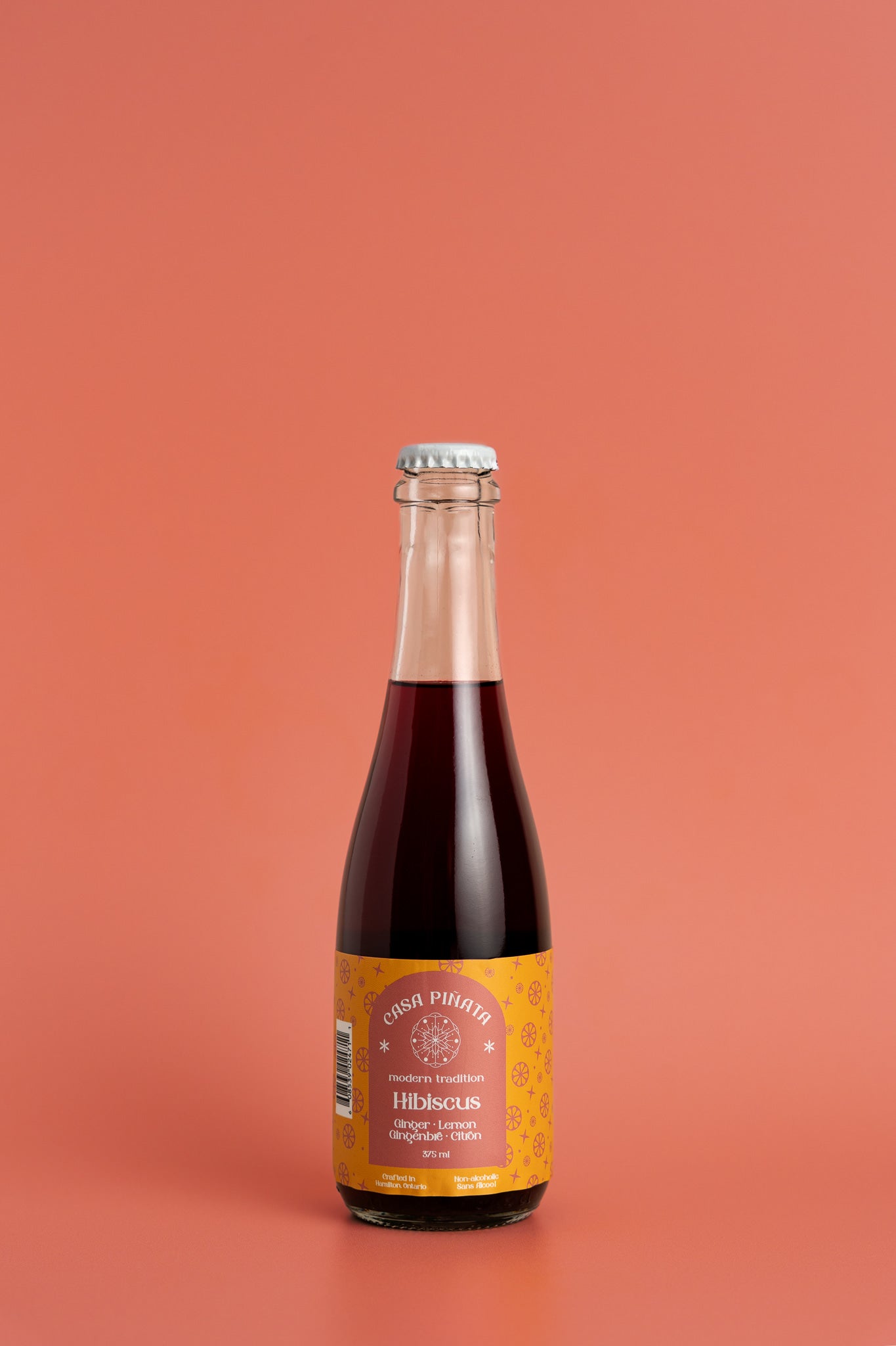 375ml clear champagne bottle of Casa Piñata Hibiscus Spritzer  against a red background.